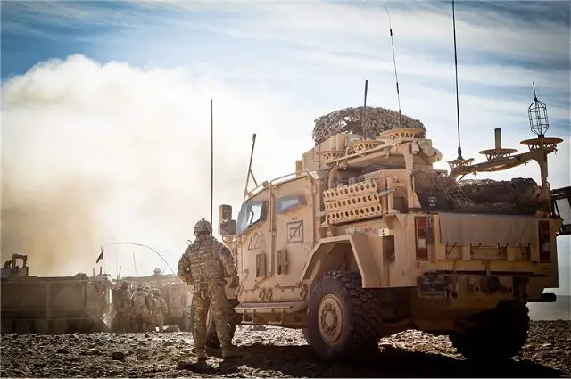 A British soldier near Husky armoured vehicle observes the controlled detonation of an improvised explosive device unearthed by Afghan National Army soldiers and destroyed by Afghan explosive ordnance disposal technicians 
