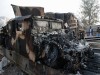 Pakistani security officials stand near burnt military vehicles parked near trucks that were hit by rocket-propelled grenades fired by militants, on the outskirts of Peshawar December 1, 2008. Two drivers of trucks transporting supplies to Western forces in Afghanistan were killed on Monday in a grenade and gun attack near Peshawar, a transport company official said. 