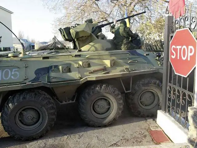 Russian troops forced their way into a Ukrainian airbase in Crimea with armored vehicles, automatic fire and stun grenades on Saturday, March 22, 2014, injuring a Ukrainian serviceman and detaining the base's commander for talks.
