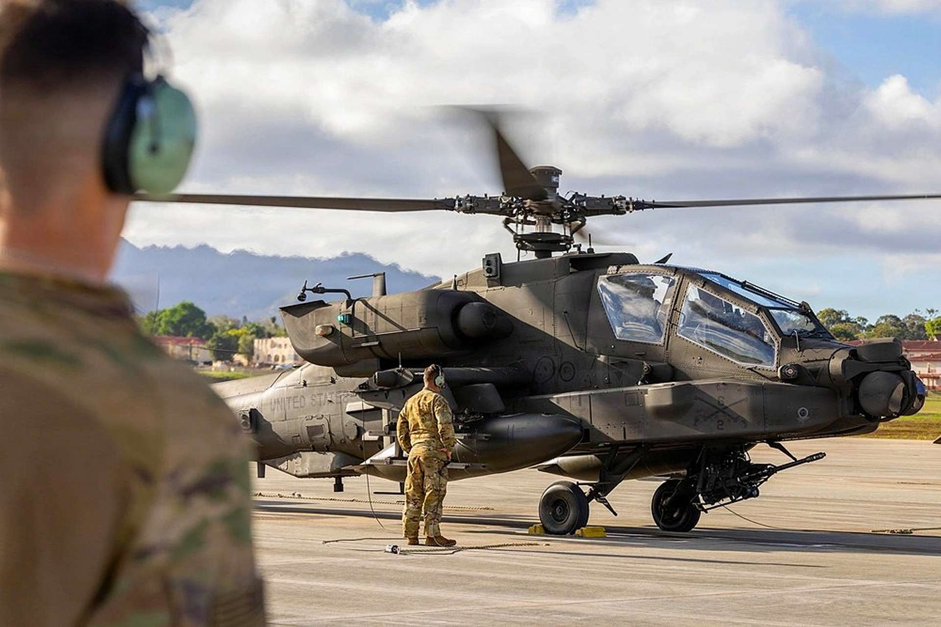 The Apache helicopter is a twin-engine, tandem-seat attack aircraft known for its sharp, angular frame, heavy weapon pylons, and the steady, throaty rotor beat that signals its combat-focused design (Picture Source: U.S. Army)