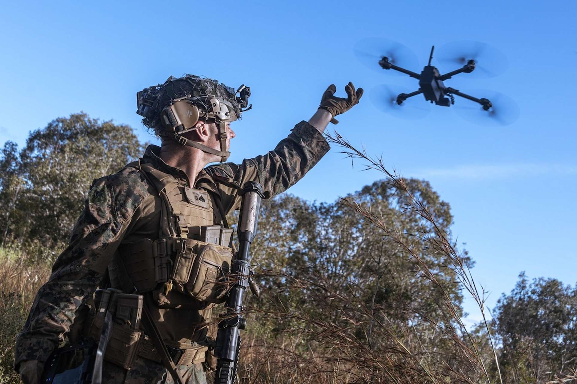 U.S. Marine Corps Cpl. launches a small drone during training in Queensland, Australia, July 2025, reflecting the War Department’s drone dominance push (Picture Source: U.S. Department of War)