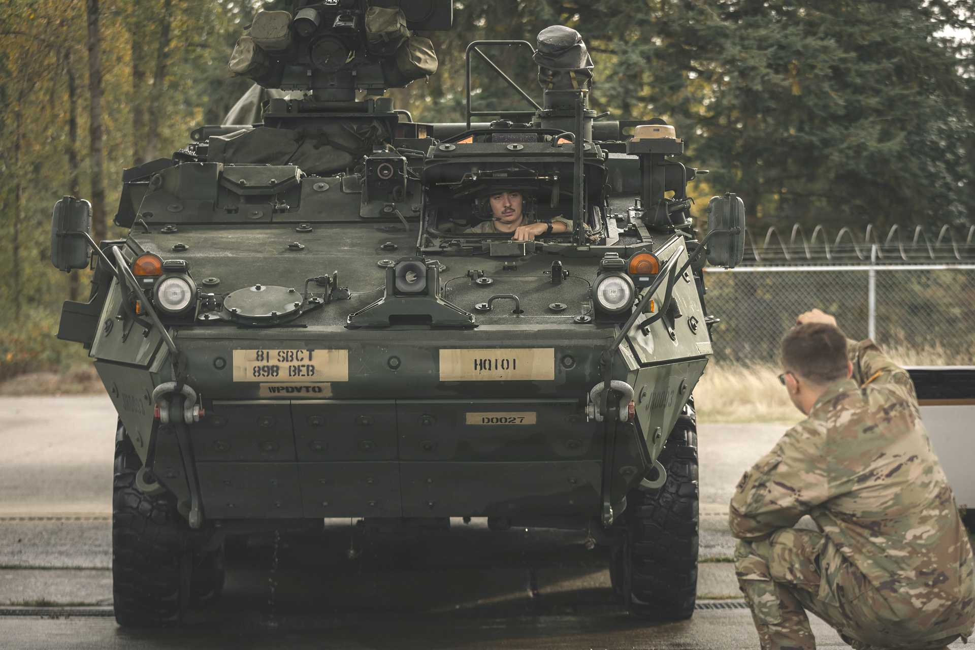 U.S. Soldiers from the 898th Brigade Engineer Battalion, part of the 81st Stryker Brigade Combat Team, Washington National Guard, direct a Stryker armored vehicle to the wash rack for turn-in at the Unit Training and Equipment Site on Joint Base Lewis-McChord, Washington, Oct. 17, 2025.
