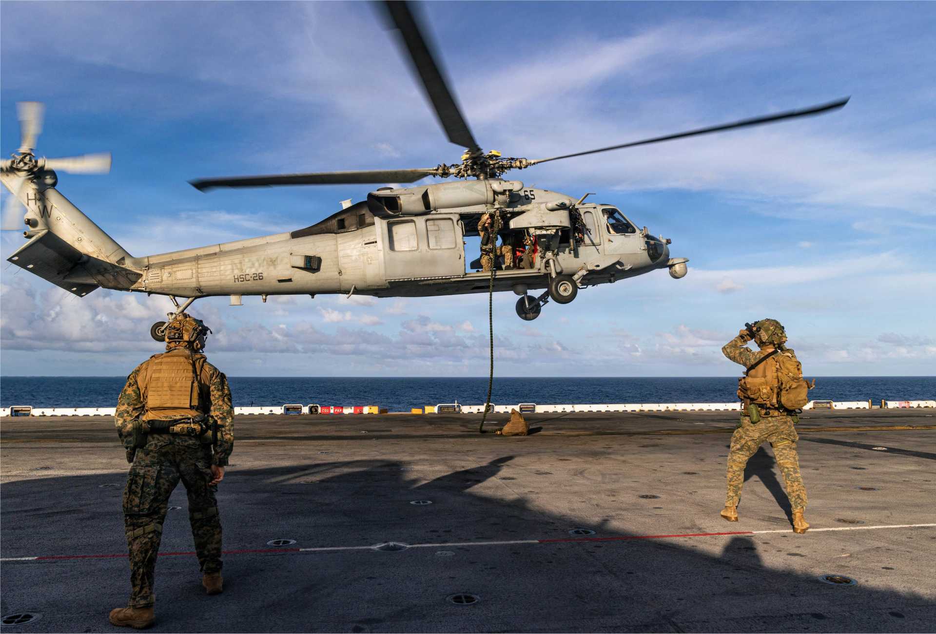 U.S. Marines with the 22nd Marine Expeditionary Unit conduct fast rope insertion drills from a U.S. Navy MH-60S Sea Hawk onto the flight deck of the USS Iwo Jima (LHD 7) in the Caribbean Sea, November 15, 2025.