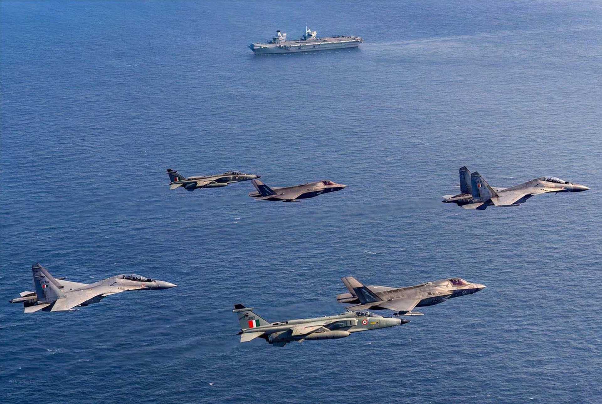 Indian Air Force Su-30MKIs and Jaguars join two British F-35B Lightning IIs in a flypast over HMS Prince of Wales during Exercise Konkan 2025, marking the first-ever joint carrier operations between the UK and India.