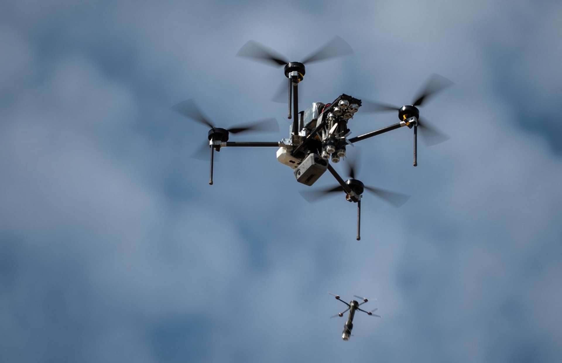 The Australian-made DefendTex D155 heavy-lift drone acts as a “mothership” for multiple Drone 40 micro-UAVs, carrying up to 13 kg of payload for about 90 minutes and deploying reconnaissance or strike drones mid-air to extend battlefield reach (Picture source: Singapore Ministry of Defense).