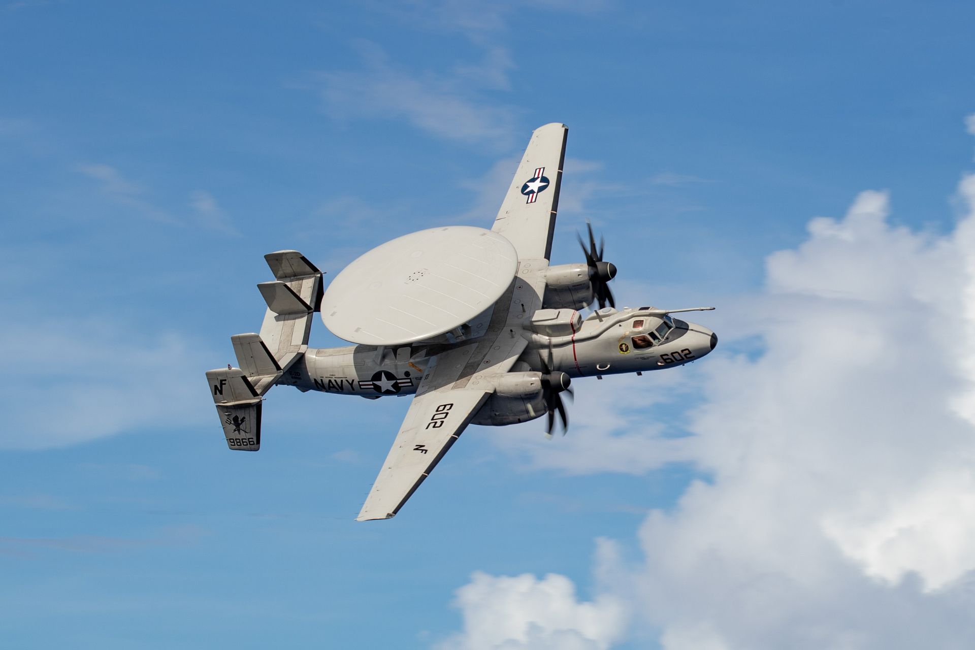 E-2D Advanced Hawkeye assigned to Airborne Command and Control Squadron (VAW) 125 flies over the Nimitz-class aircraft carrier USS George Washington (CVN 73) in the Celebes Sea on November 29, 2025. The aircraft is set to receive the Block II modernization, which will introduce a new digital architecture, increased computing capacity, and an Open Mission Systems framework to support future capability upgrades. (Picture source: US DoD)