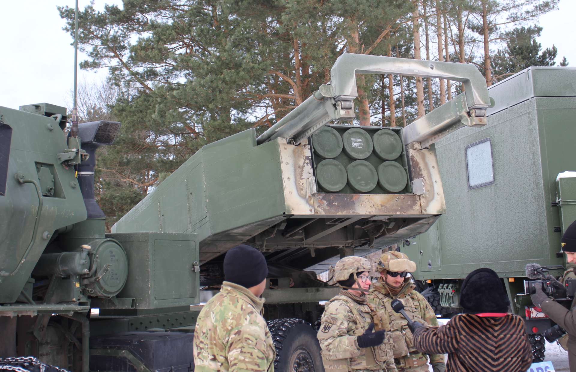 HIMARS’ single Launch Pod Container carries six 227 mm rockets or one ATACMS-class missile, giving the wheeled launcher a lighter, faster “shoot-and-scoot” design than the tracked M270’s dual-pod layout, with an armored cab and compact cradle that elevates and slews the sealed pod for rapid, protected firing from dispersed positions (Picture source: Army Recognition Group).