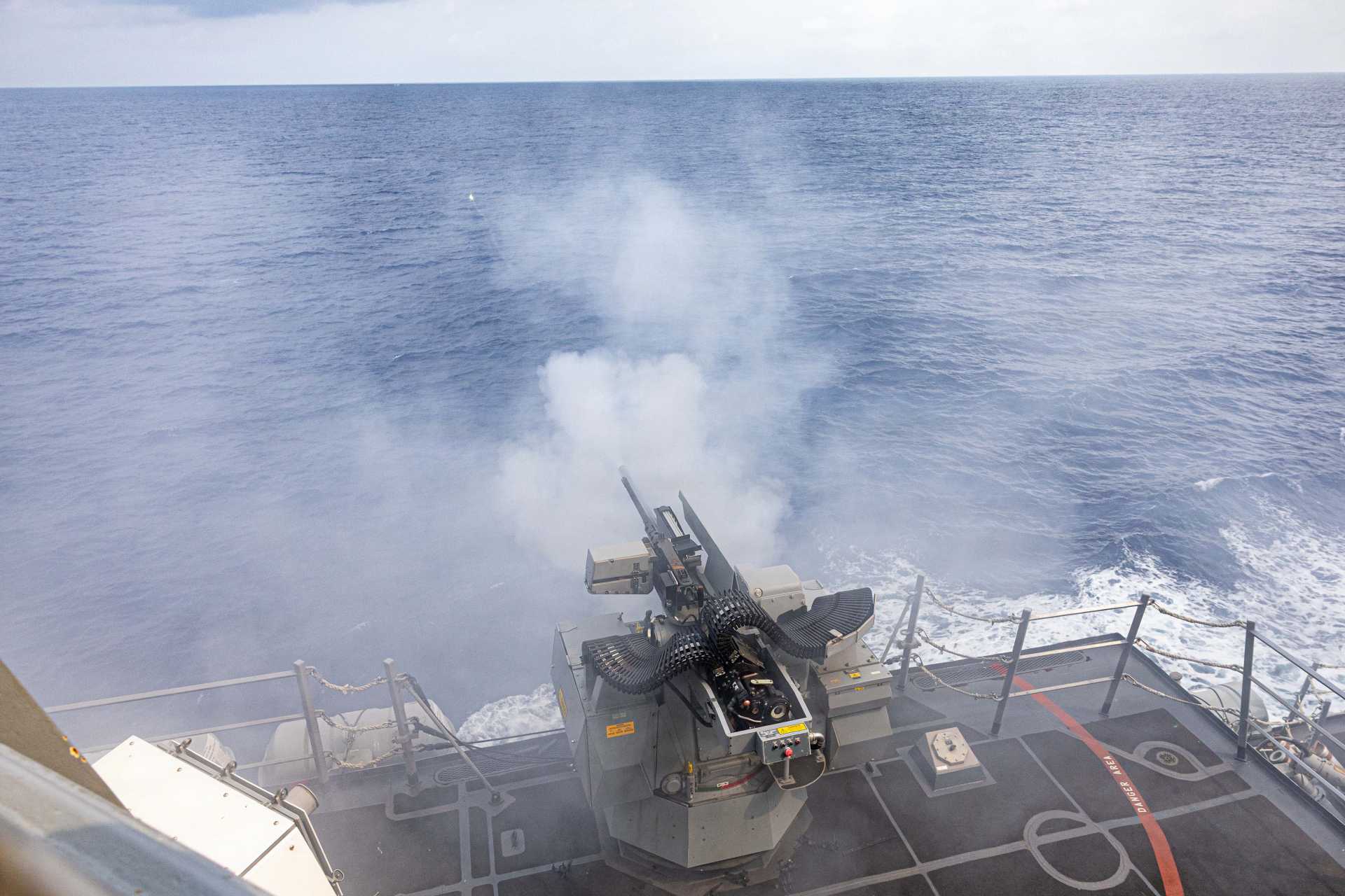A Mk 38 Mod 4 30mm gun fires during a live-fire exercise aboard the Arleigh Burke-class guided-missile destroyer USS Mustin (DDG 89) in the South China Sea on April 17, 2026.