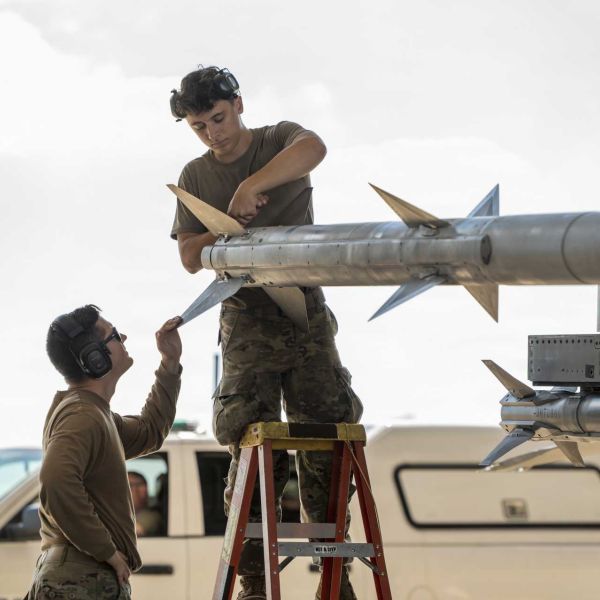 U.S. Air Force Tech. Sgt. Jordon Gonzales and Airman 1st Class Lukas Pollock, aircraft armament systems specialists with the Ohio National Guard’s 180th Fighter Wing, prepare the fins of an AIM-120 AMRAAM air-to-air missile mounted on an F-16 Fighting Falcon before a training flight in Swanton, Ohio, on September 29, 2026. (Picture source: U.S. Department of War/Defense)