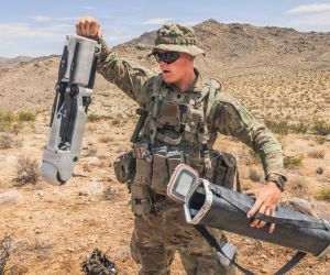 U.S. Army Spc. Tanner Shanklin, assigned to the 4th Infantry Division, prepares a Rogue 1 unmanned aerial system for employment during Project Convergence Capstone 6 at Fort Irwin, California, on July 20, 2026. The man-portable VTOL loitering munition is being evaluated for reconnaissance and precision-strike missions against targets beyond direct line of sight.